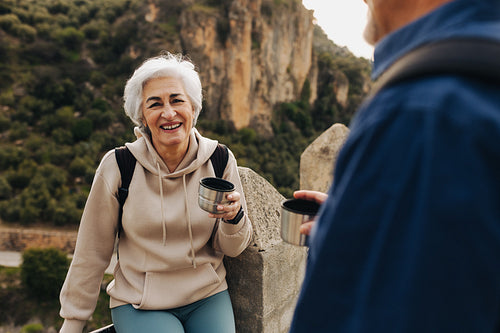 Elderly couple taking a coffee break while hiking outdoors
