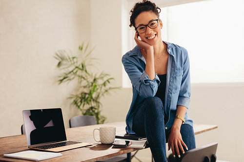 Beautiful woman sitting at table in her home office