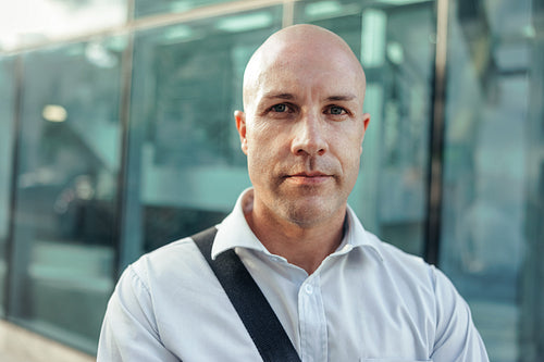 Businessman looking at the camera while standing outside his workplace