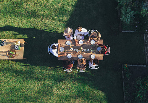 Friends enjoying meal at outdoor party in backyard