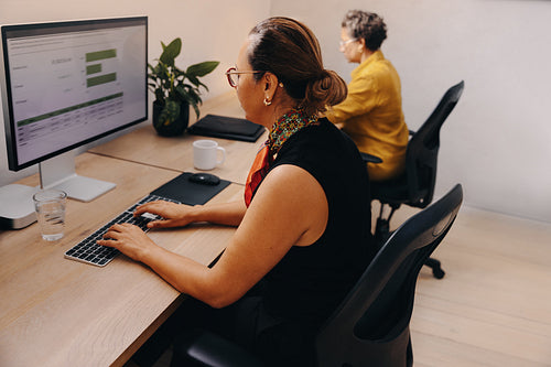 Focused professionals working productively on computers in a modern office setting