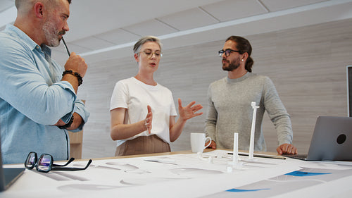 Creative ideas for a windmill design: Female engineering expert leading her team in a wind energy project