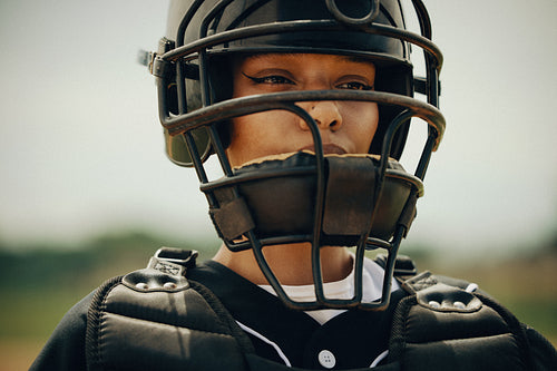 Focused baseball catcher wearing protective gear, ready for action on the field