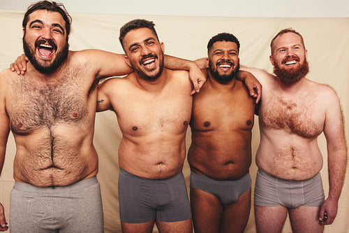 Studio shot of shirtless men embracing each other