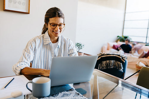 Young woman works on laptop at home office