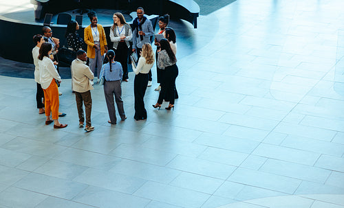 Corporate team in a large office lobby engaged in a professional discussion