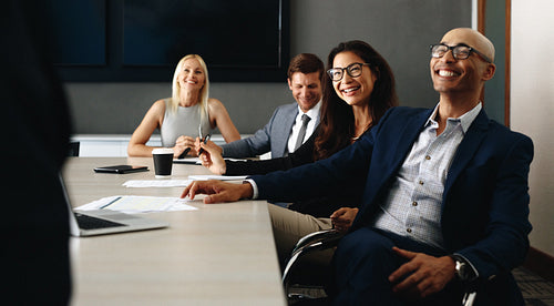 Team of happy business people hearing a presentation in an office meeting