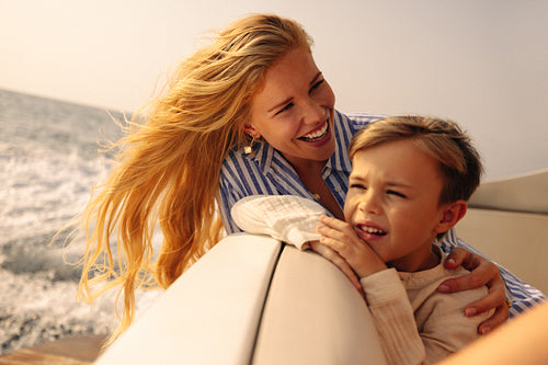 Joyful mother and her son sharing a holiday boat ride on a sunny day