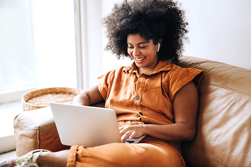 Young businesswoman working on a laptop in an office lobby