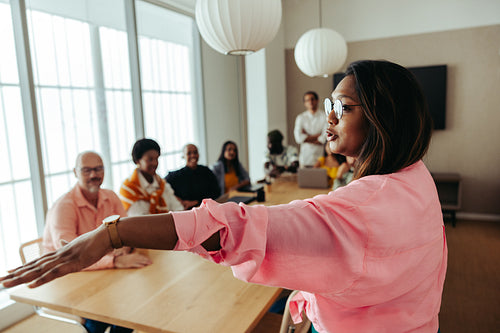 Confident Indian businesswoman leading a diverse meeting with engaged team members