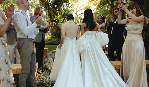 Outdoor wedding ceremony celebrating a same-sex marriage with friends and family
