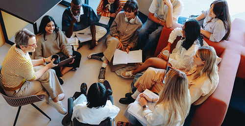 College students gathering on campus in collaborative group study session with a diverse mix of young adults