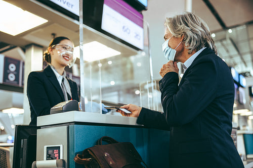 Business traveler doing the check-in at the airport during pande