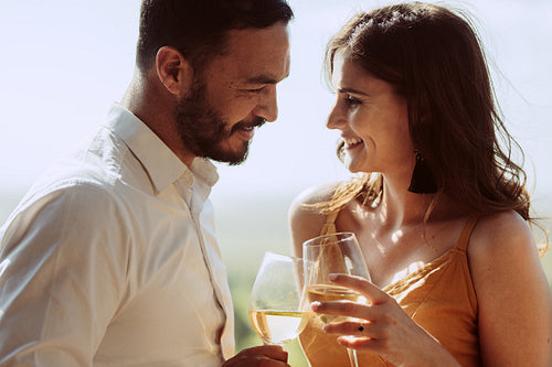 Close up of a smiling couple together holding wine glasses