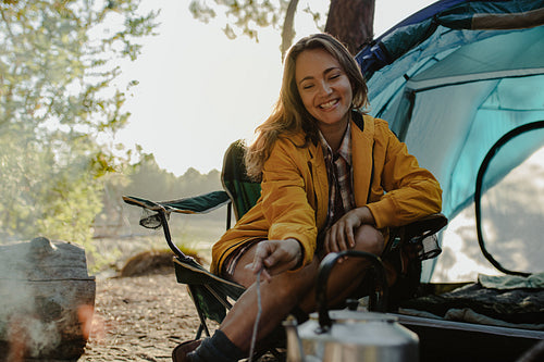Smiling woman sitting at campsite