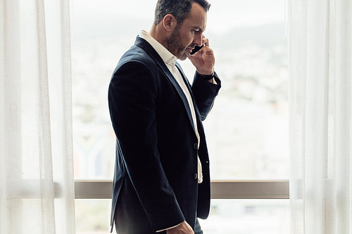 Businessman in hotel room having discussing over phone