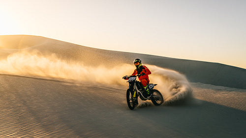 Dirt bike off roading on sand dune