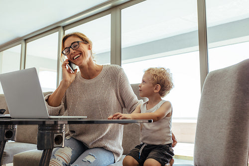 Busy woman with son in home office