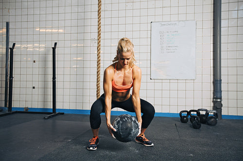Woman doing crossfit workout with medicine ball  at gym