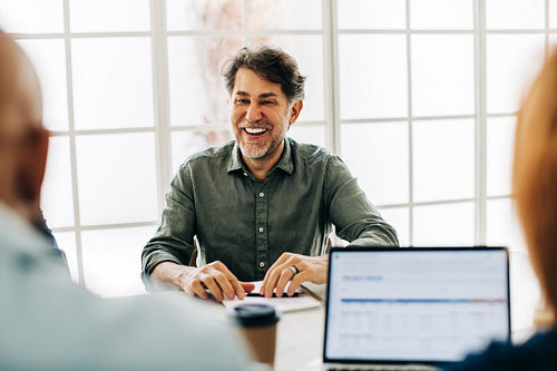 Mature business man having a meeting with his team in an office