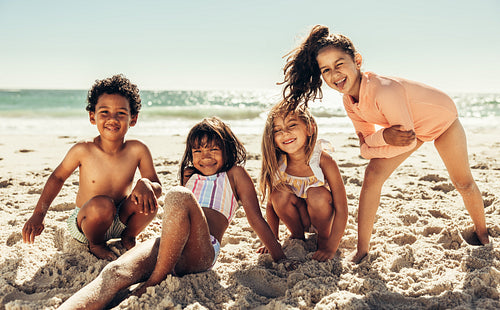 Adorable kids relaxing in sea sand at the beach