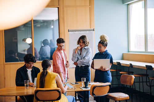 Group of young professionals engaged in a discussion at an office table