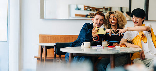 Friends taking a selfie together in a cafe