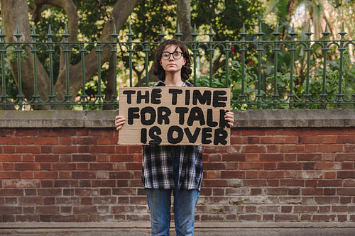 Youth activist holding a banner outdoors