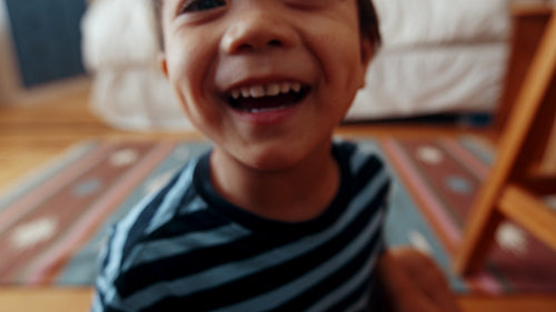 Curious little boy chatting and having a good time, his face zooming into the camera