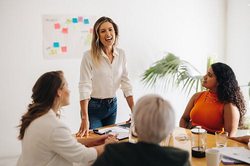 Cheerful businesswoman leading a meeting in a boardroom