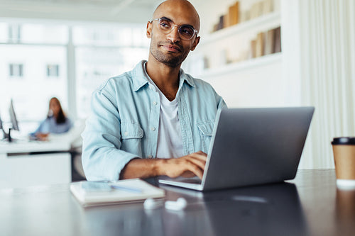 Thoughtful business man working on a laptop in an office