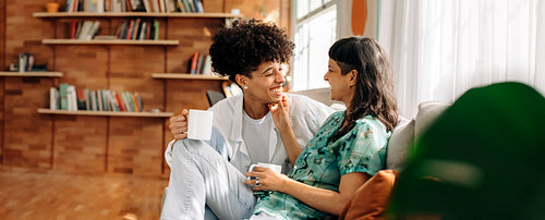Flirty couple having morning coffee together at home
