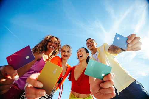 Students hold payment cards together outdoors for youth finance and student loan concept