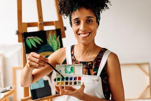 Confident young painter holding a palette