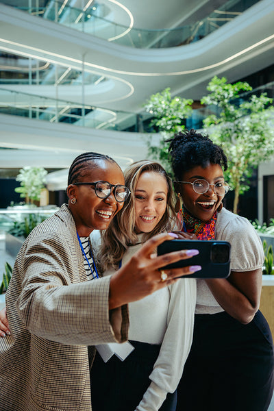 Diverse group of colleagues taking a selfie together at work