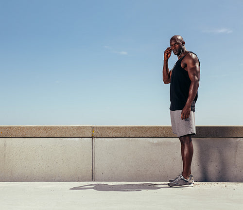 Fit young man standing on a walkway