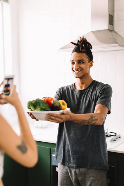Young couple taking a photo of their food at home