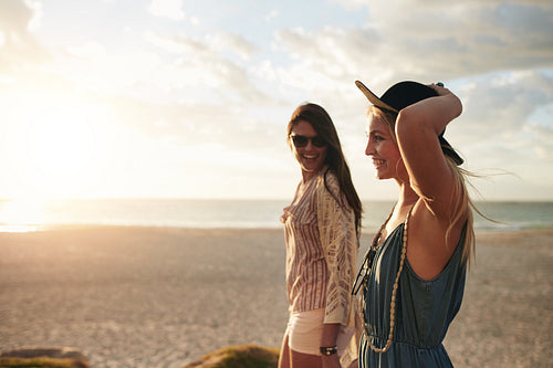 Best friends strolling along coastline on a sunny day