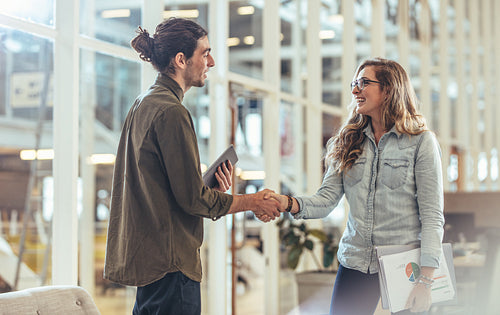 Business partners greeting each other in office