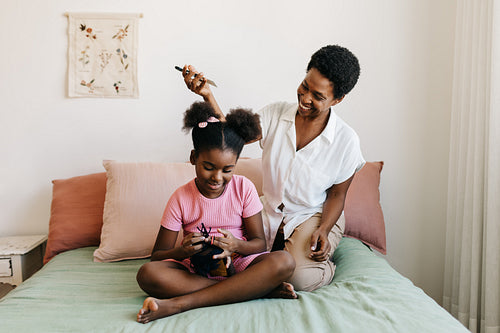 Black motherhood: Woman styling her daughter's afro hair