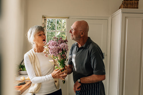 Senior man giving a bouquet to his wife