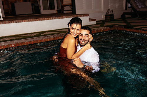 Young couple swimming in their clothes at night
