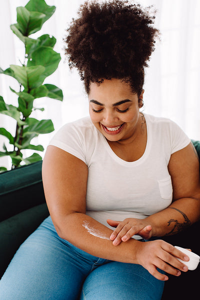 Beautiful female applying beauty cream on hand