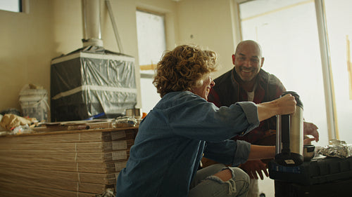 Mature couple taking a coffee break during home renovation
