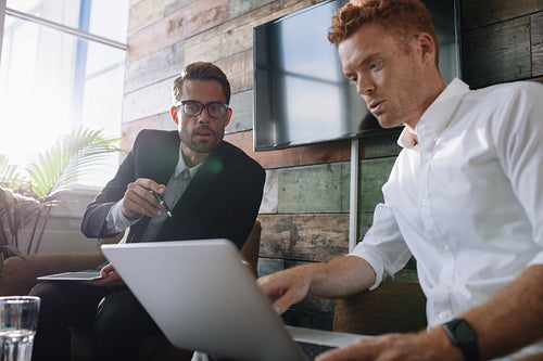 Business colleagues working on laptop during meeting