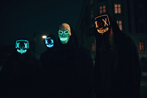 People with illuminated masks gathering outdoors at nighttime