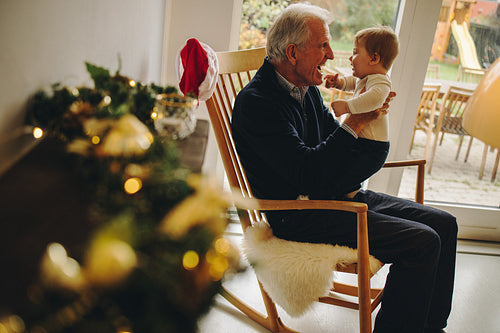 Grandfather playing with grandson during christmas