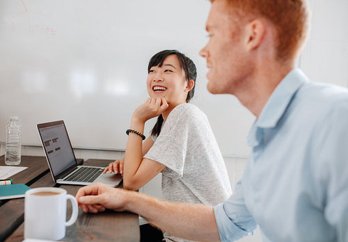 Two happy business people sitting at conference room