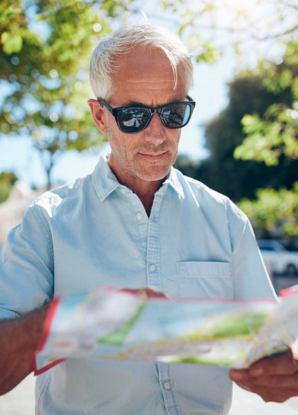 Senior tourist looking at city map