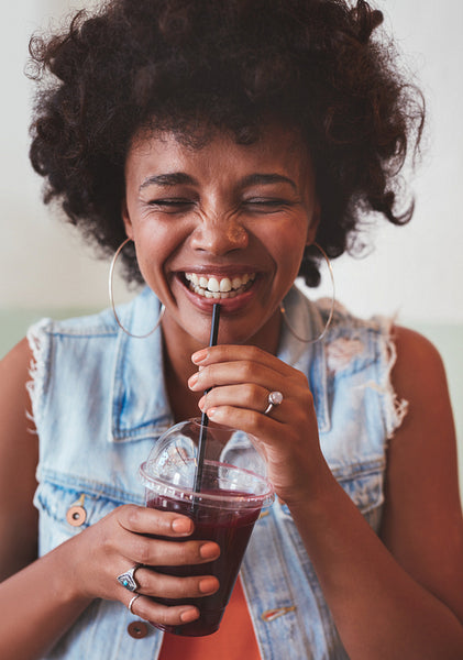 Happy young woman enjoying fresh fruit juice